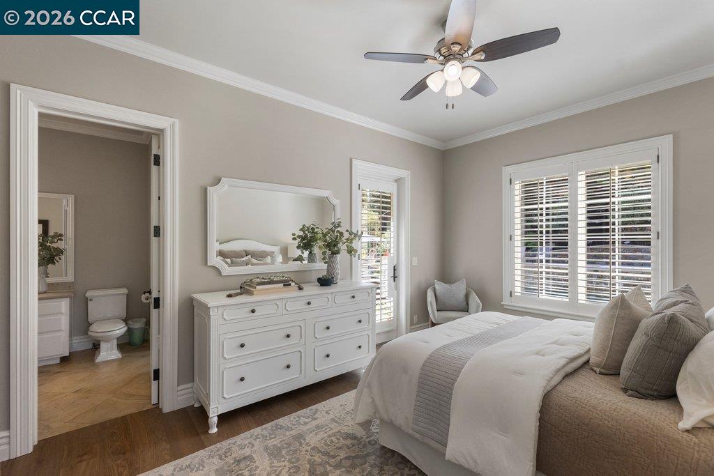 Bedroom with a white dresser, ceiling fan, and adjoining bathroom.