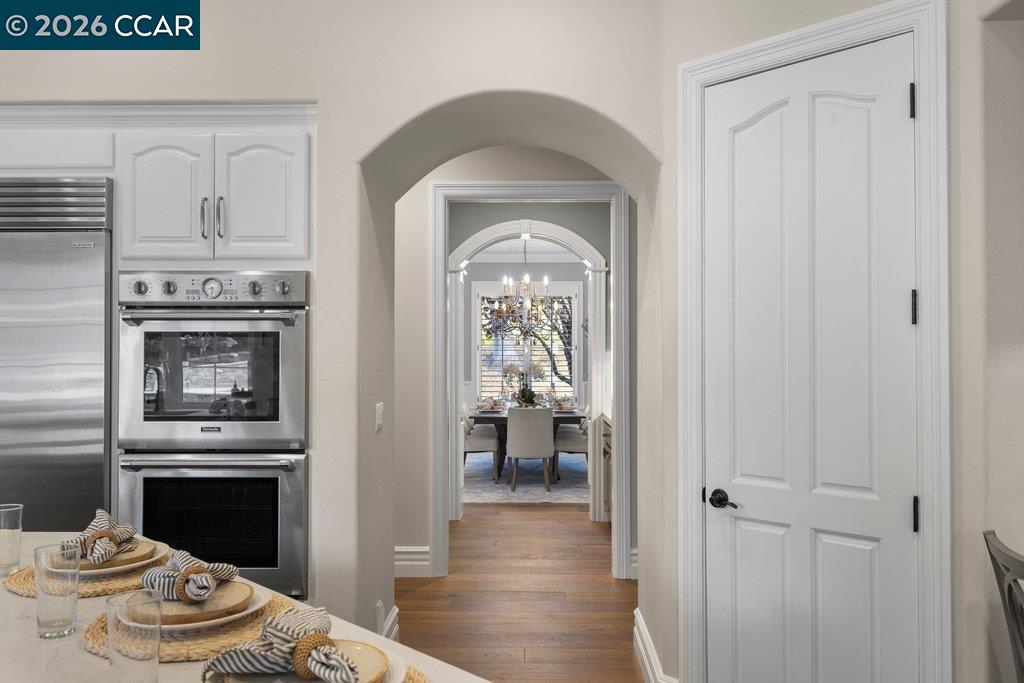 Kitchen with stainless steel appliances and a view through an archway to the dining room.