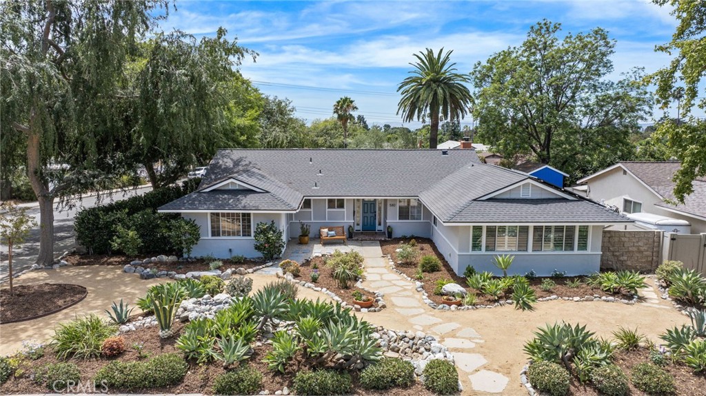 Single-story gray home with a blue front door and drought-tolerant landscaping, viewed from above.