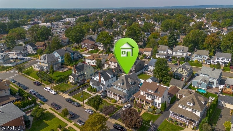 Aerial view of a residential neighborhood with a green house marker over one home.
