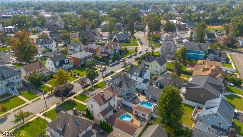 Aerial view of a residential neighborhood with detached homes and backyard swimming pools.