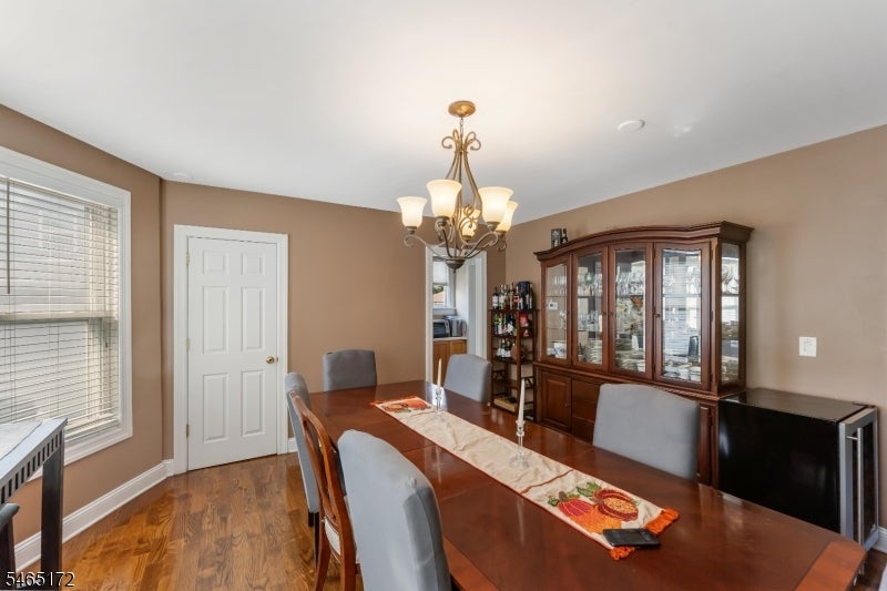 Dining room with a long wood table, chandelier, and glass-front china cabinet.
