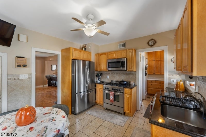 Kitchen with wood cabinets, stainless steel appliances, and a small dining table.