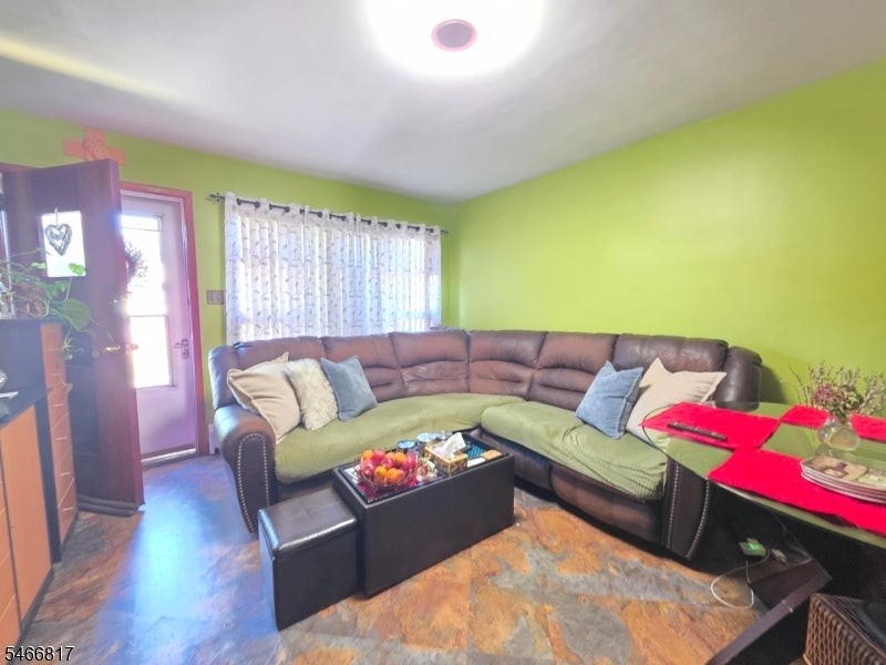 Living room with a brown sectional, green walls, and a black coffee table.