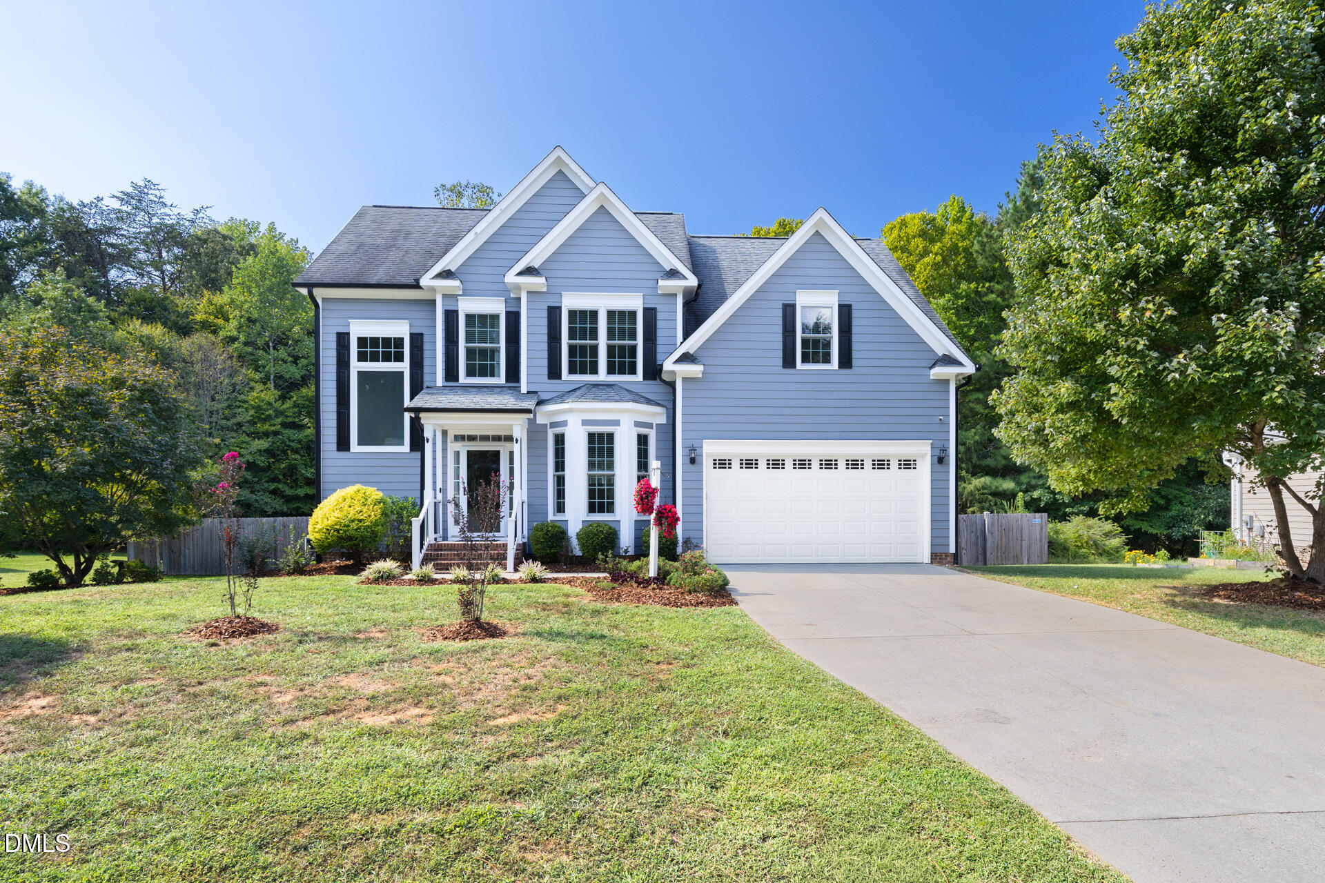 Blue-gray two-story home with white trim, multiple gables, and an attached garage.