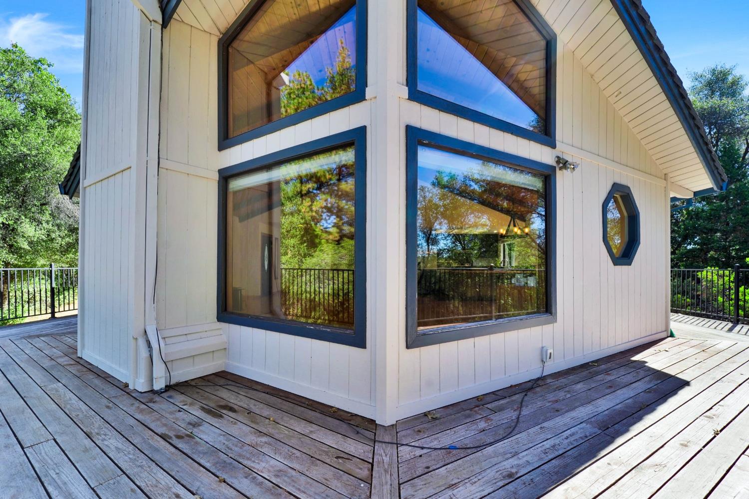 House exterior with dark-trimmed windows and a weathered wraparound deck.