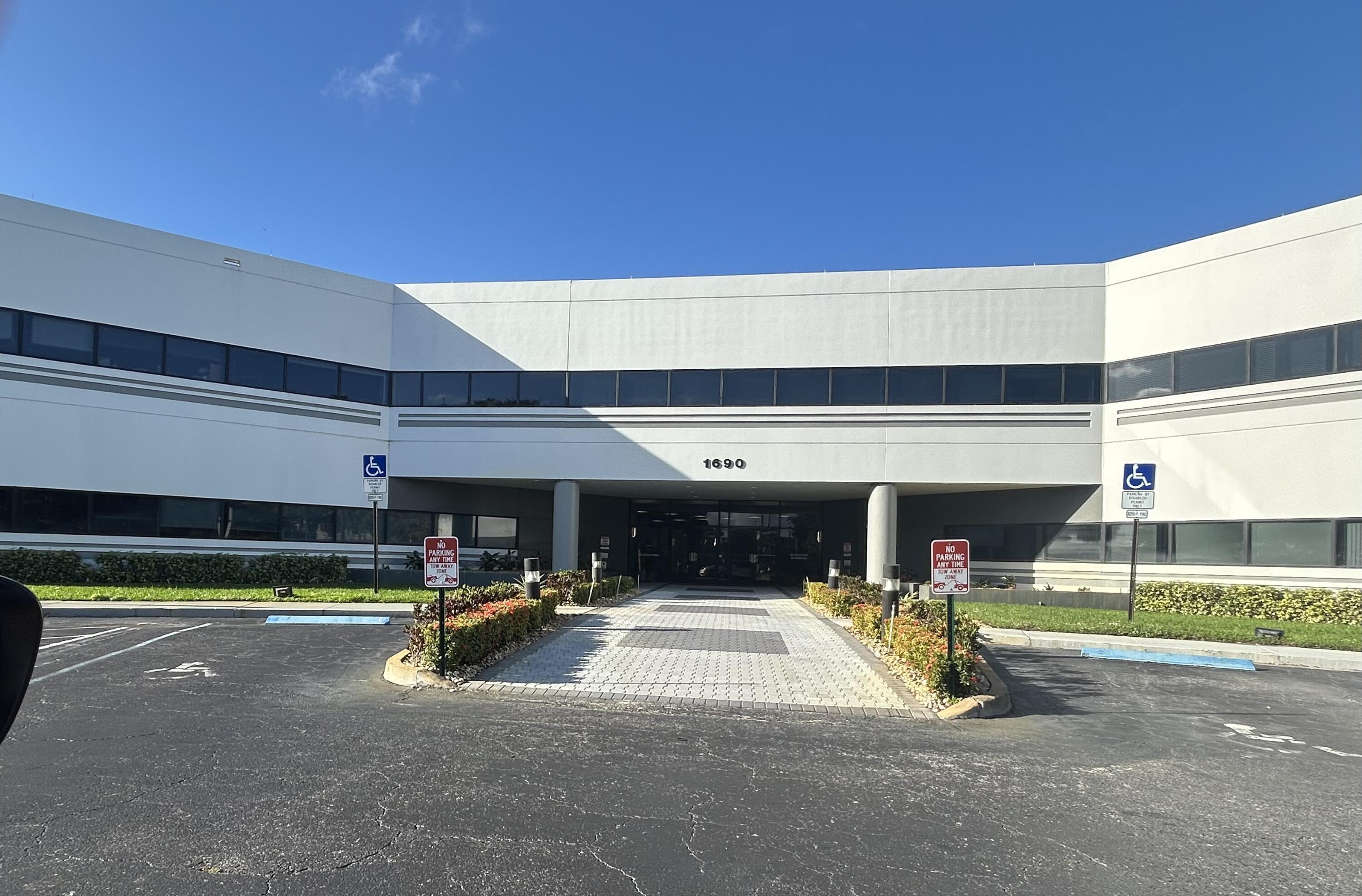 Office building entrance marked 1690, with an accessible parking area and central walkway.
