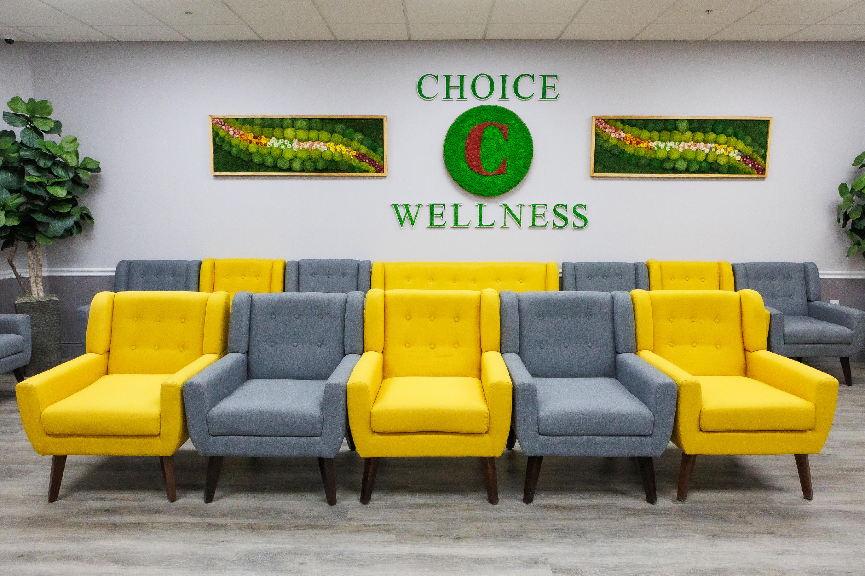 Wellness waiting area with rows of yellow and gray armchairs beneath a Choice C Wellness sign.