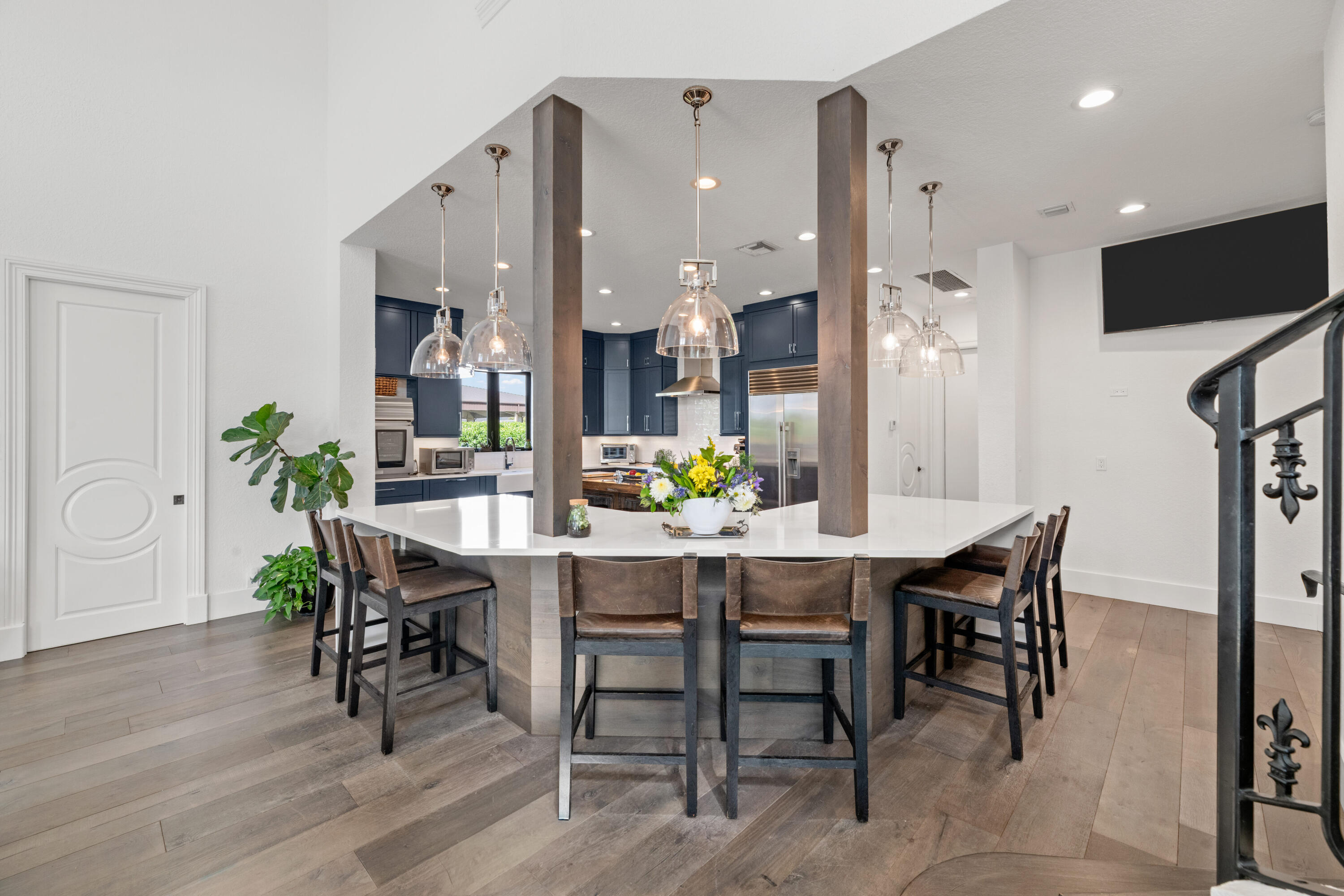 Open-plan kitchen with navy cabinets and a large island surrounded by bar stools.