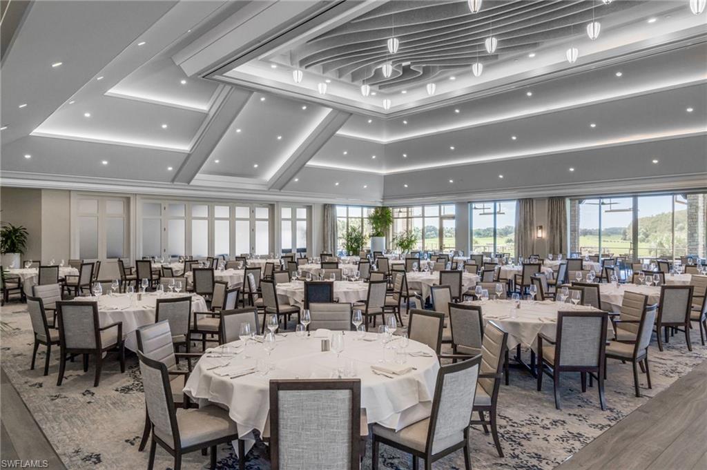 Banquet dining room with round tables, a dramatic coffered ceiling, and golf course views through large windows.