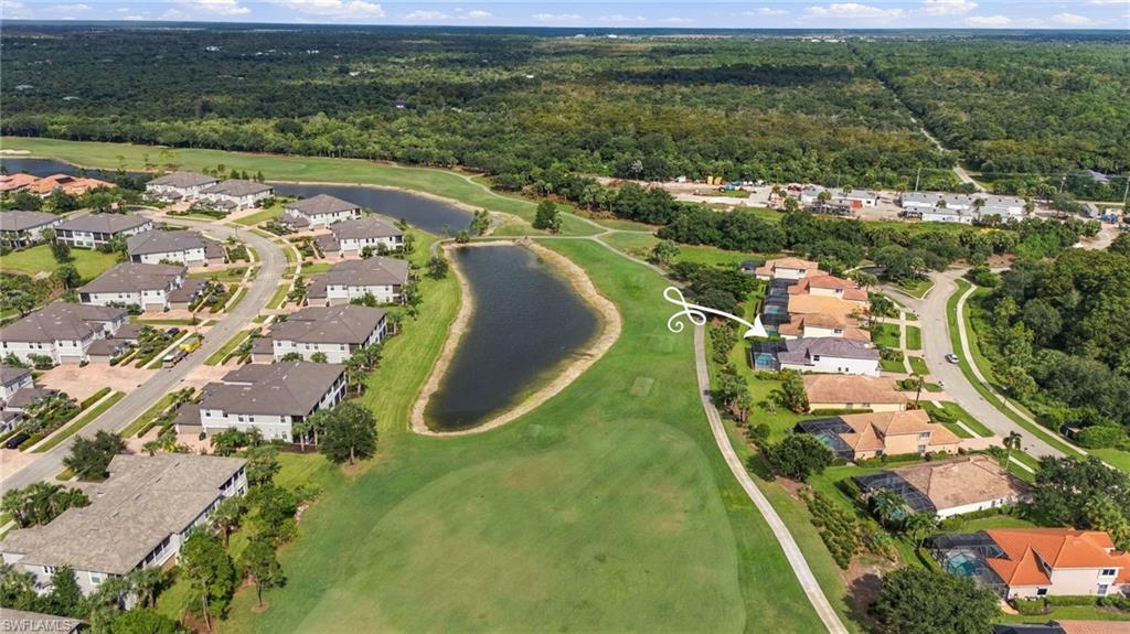 Aerial neighborhood view with an arrow marking a home beside a pond and manicured green space.