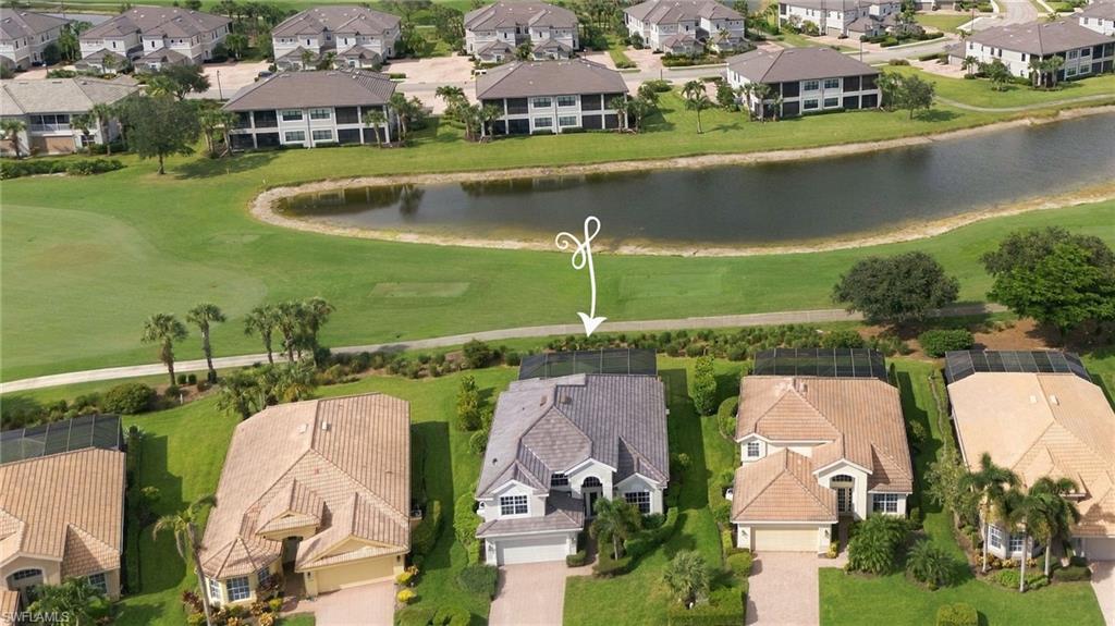 Aerial view of a home beside a pond, marked by a white arrow.