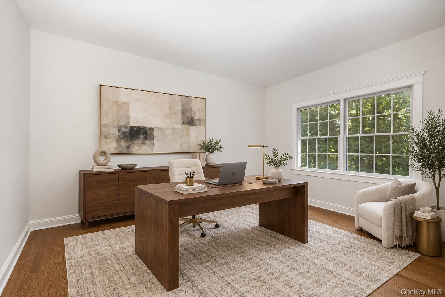 Staged home office with a dark wood desk, abstract artwork, and a wide window overlooking greenery.