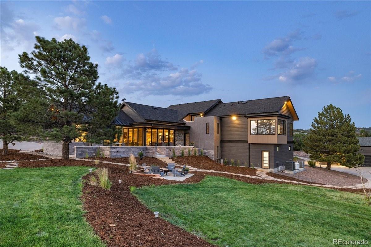 Home exterior at dusk with landscaped lawn