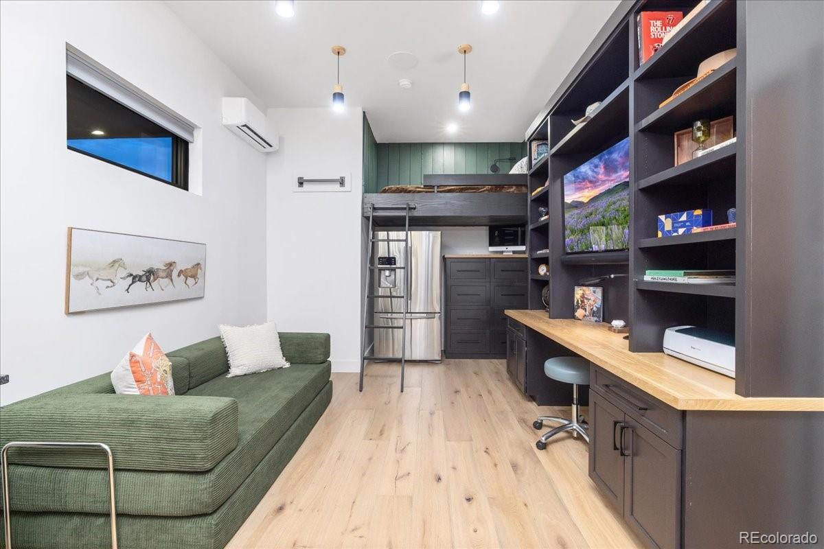 Home office with built-in shelving and green sofa