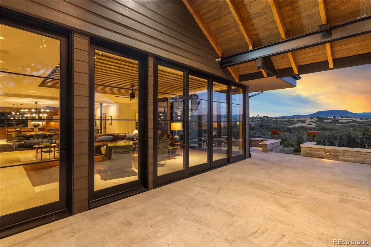 Covered outdoor living area with wood beam ceiling and mountain views