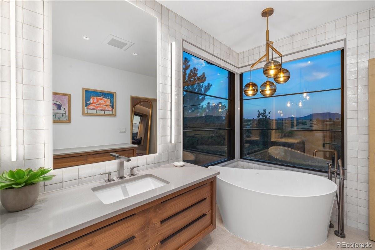 Primary bathroom with soaking tub and chandelier