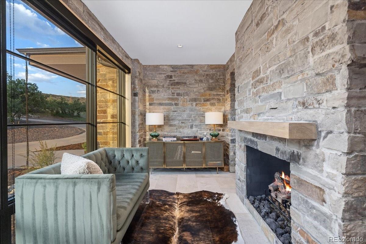 Stone fireplace with cowhide rug and velvet lounge seating