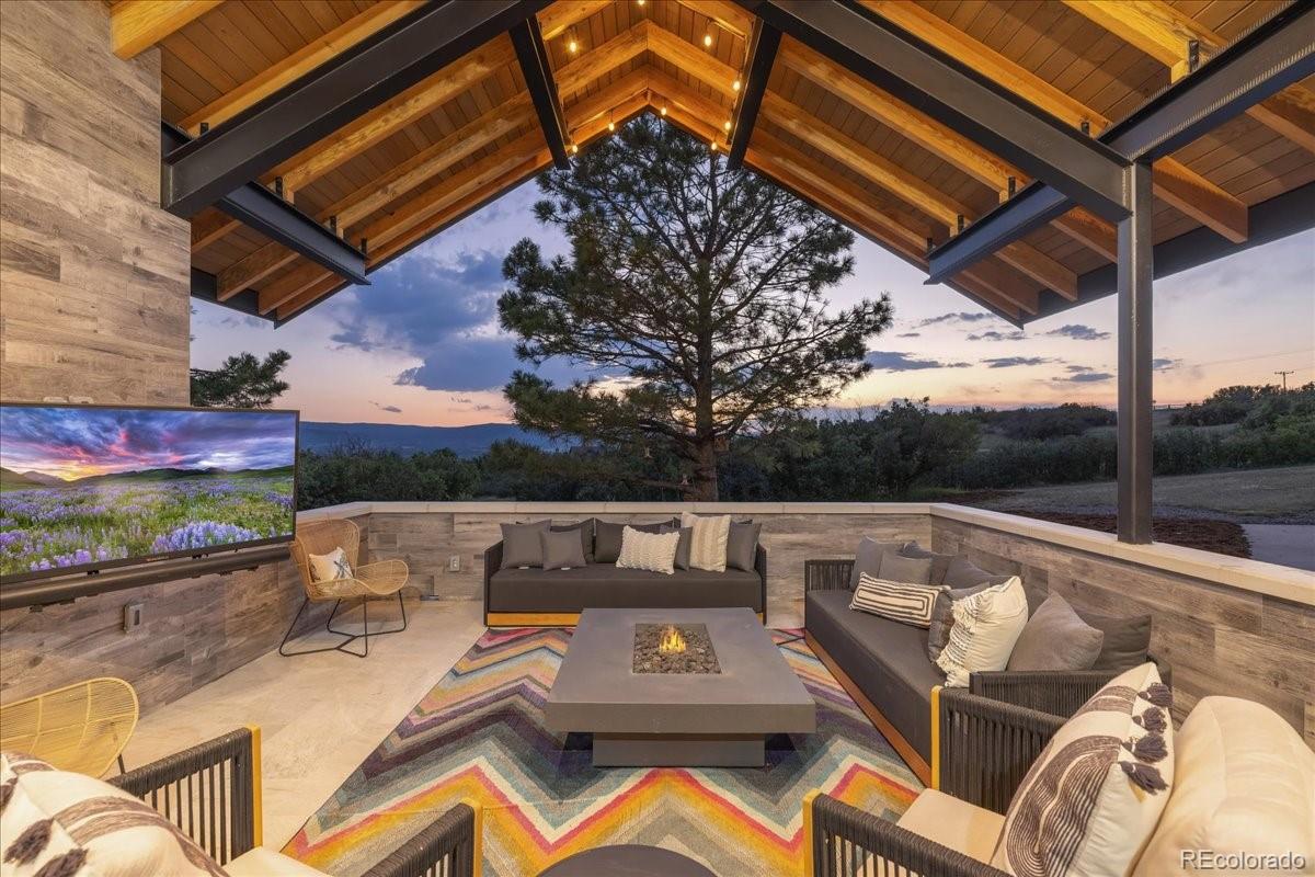 Outdoor lounge with fire pit table under covered pavilion
