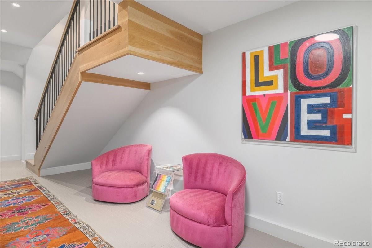 Staircase landing with pink accent chairs and colorful art