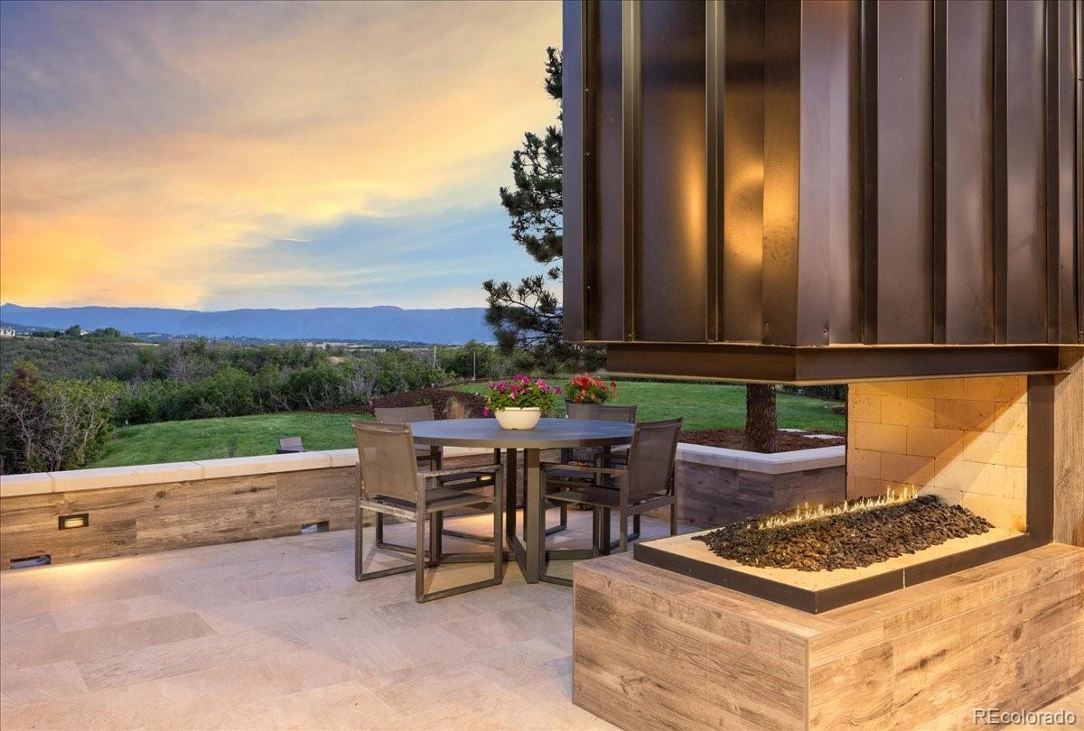  Patio dining area with fireplace at dusk