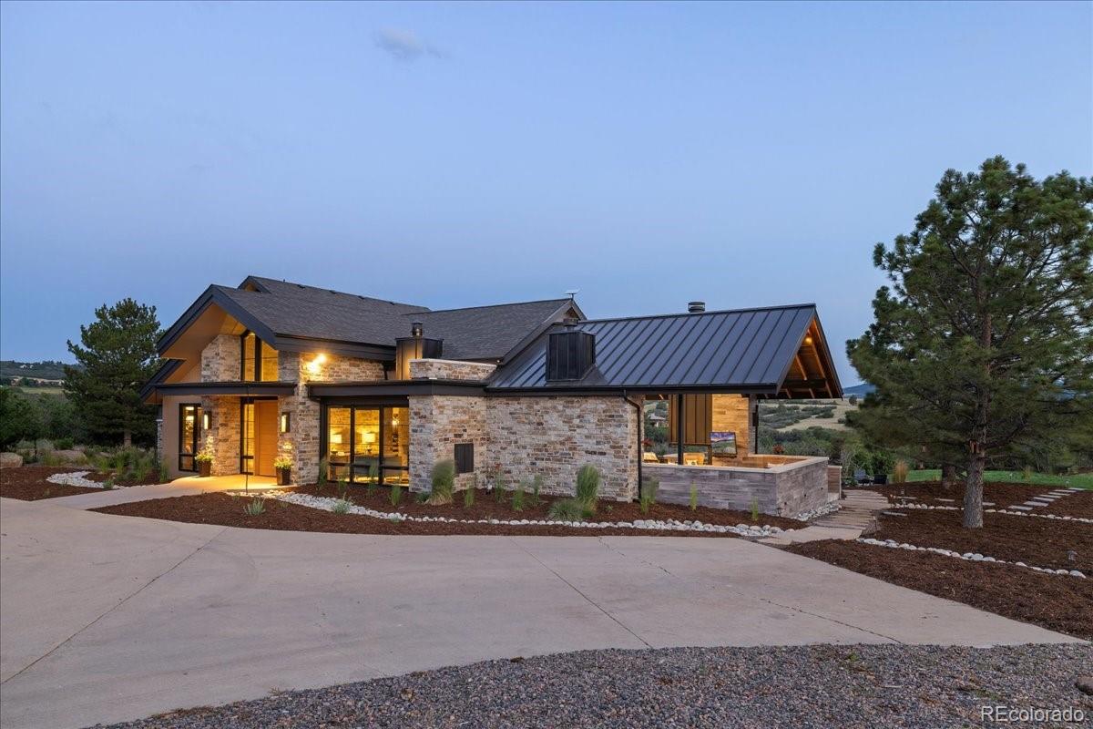 Mountain modern home exterior at dusk, second view
