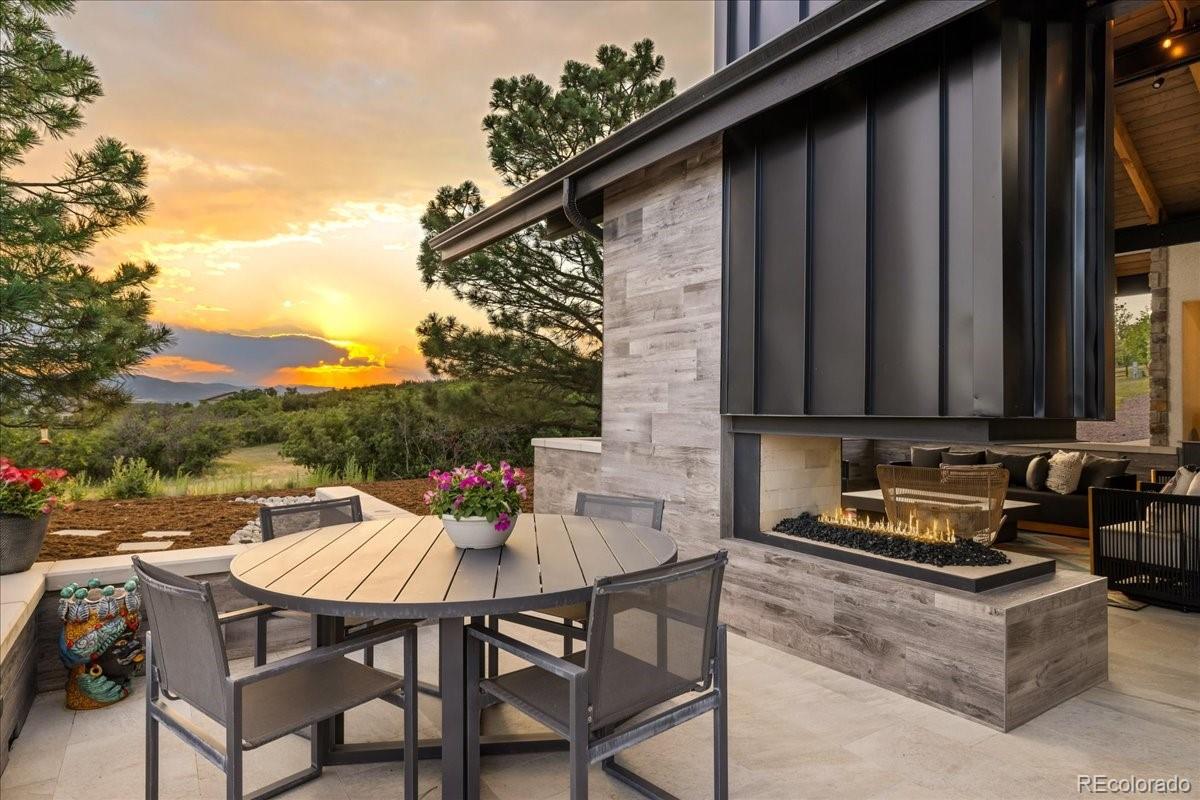 Outdoor patio with fireplace at sunset, Castle Rock estate