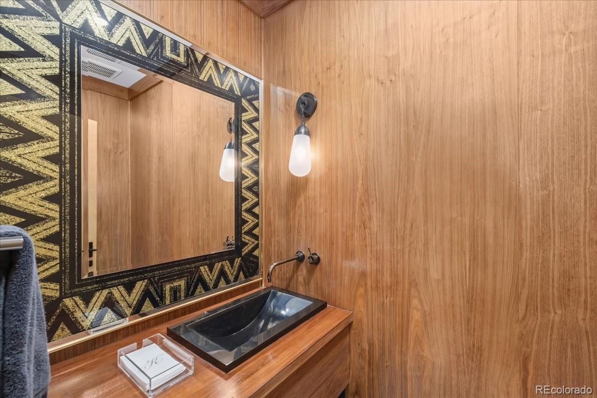 Bathroom with glass shower and gold-framed mirror
