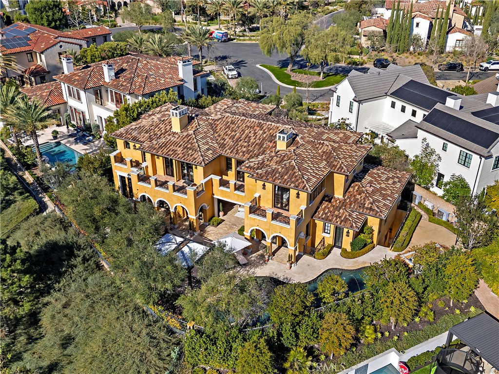 Aerial view of a Mediterranean-style home with terracotta roofs and a swimming pool.