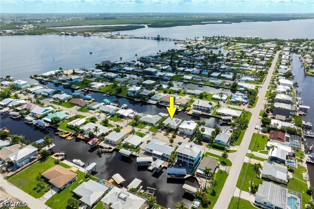 Aerial view of canal-side homes in Matlacha, with a yellow arrow marking one property.