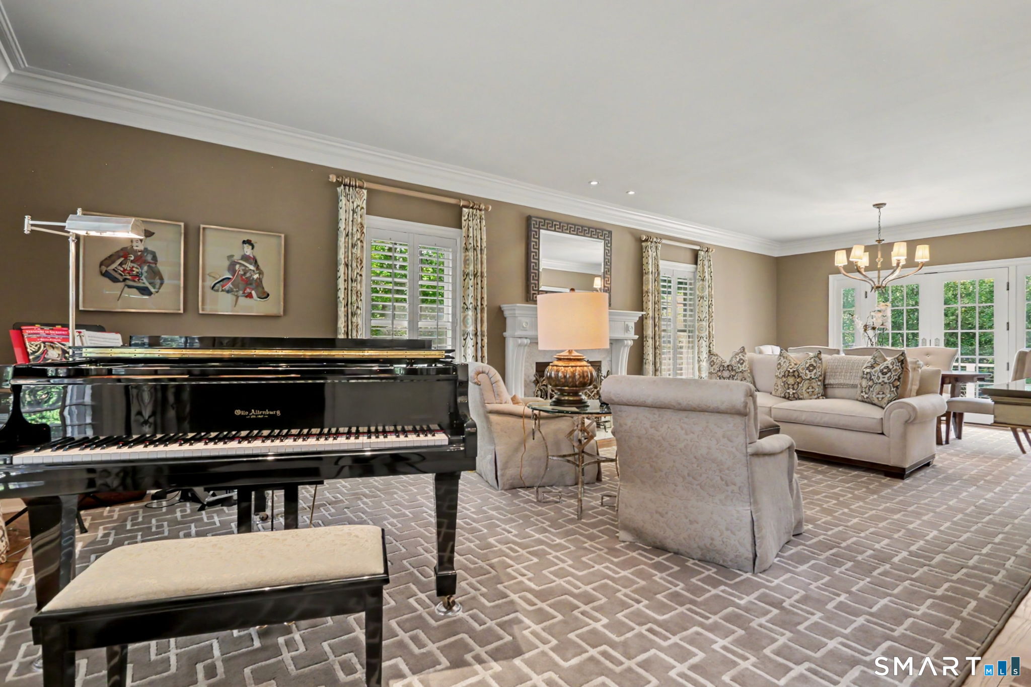 Living room with a black grand piano, neutral seating, fireplace, and glass doors to greenery.