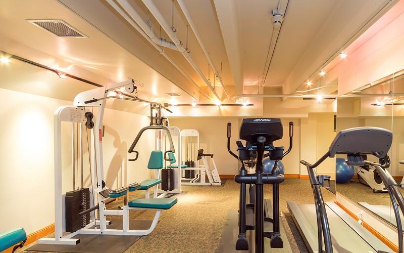 Fitness room with weight machines, cardio equipment, and blue exercise balls.