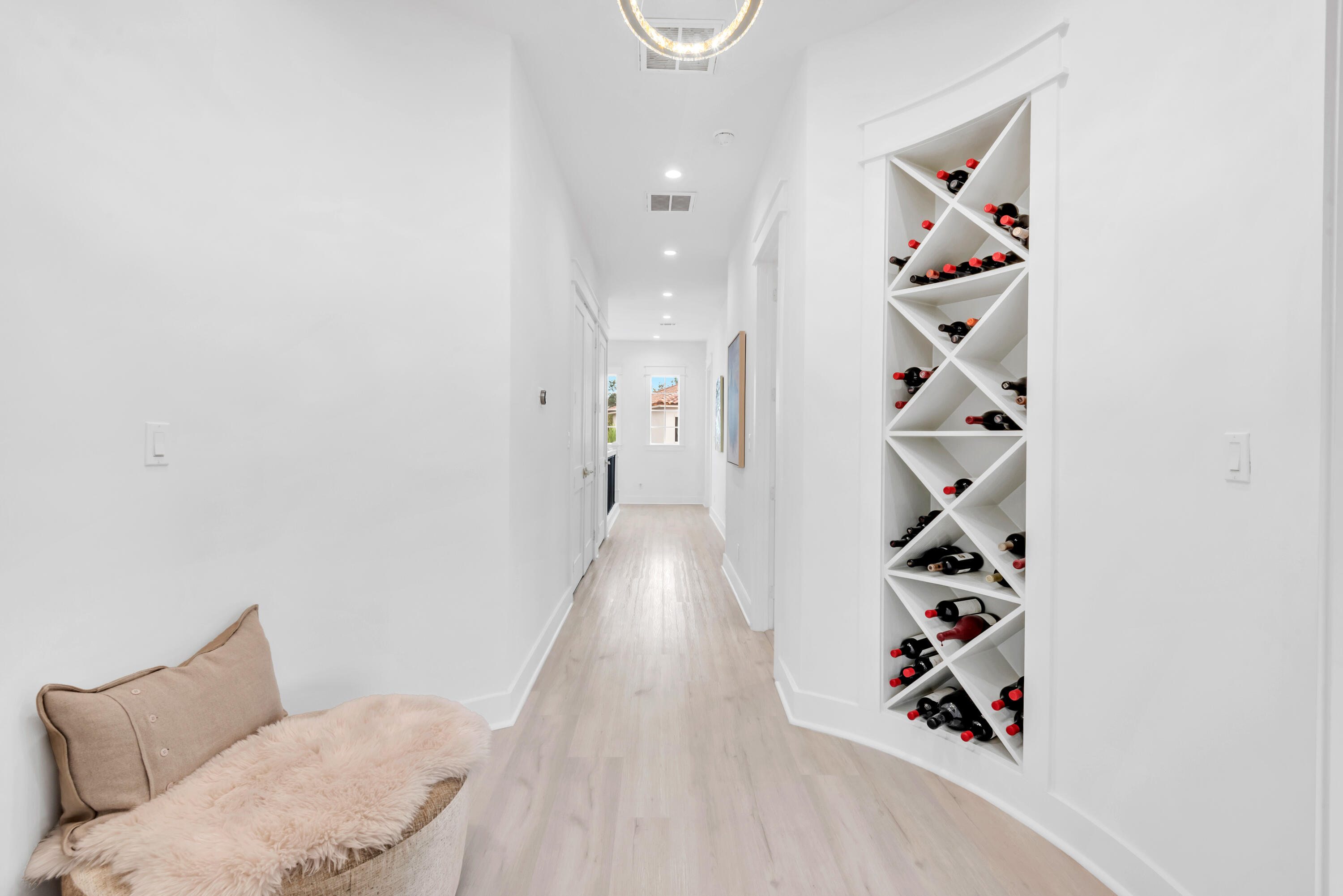 Bright hallway with a built-in wine rack and a cushioned bench.