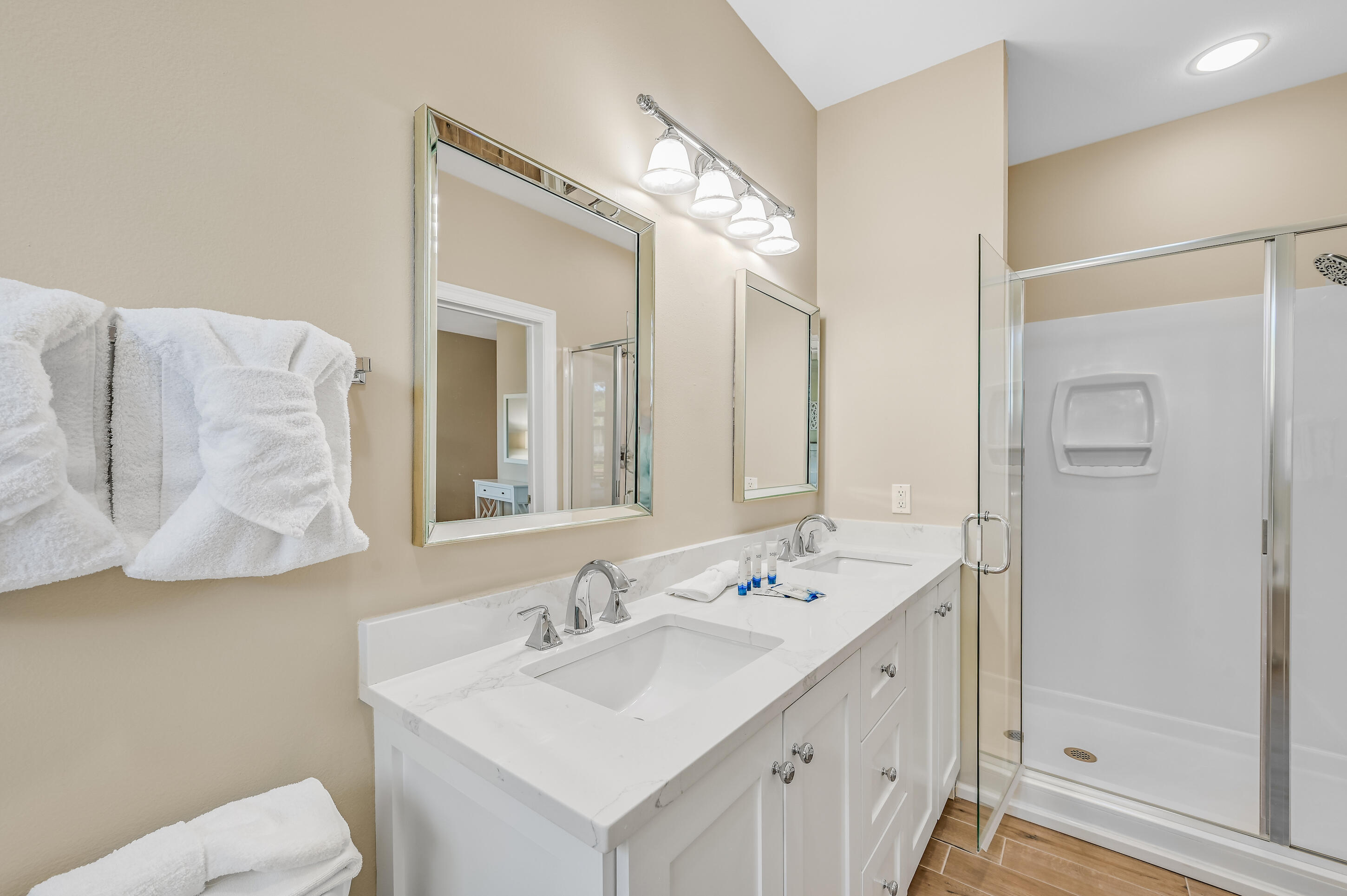 Bathroom with a white double-sink vanity, chrome fixtures, and a glass-enclosed shower.