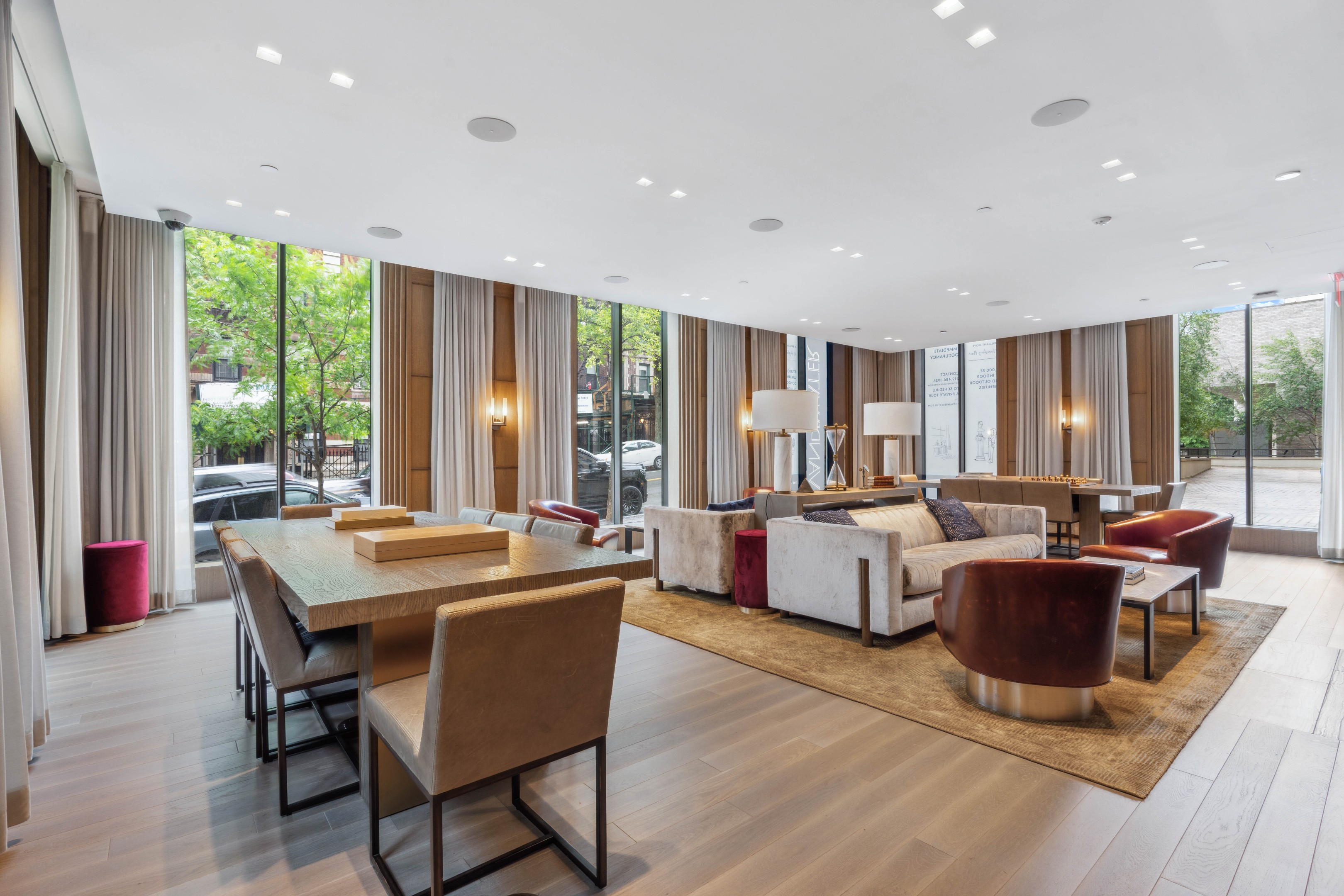 Furnished residential lounge with a dining table, seating area, and floor-to-ceiling windows.