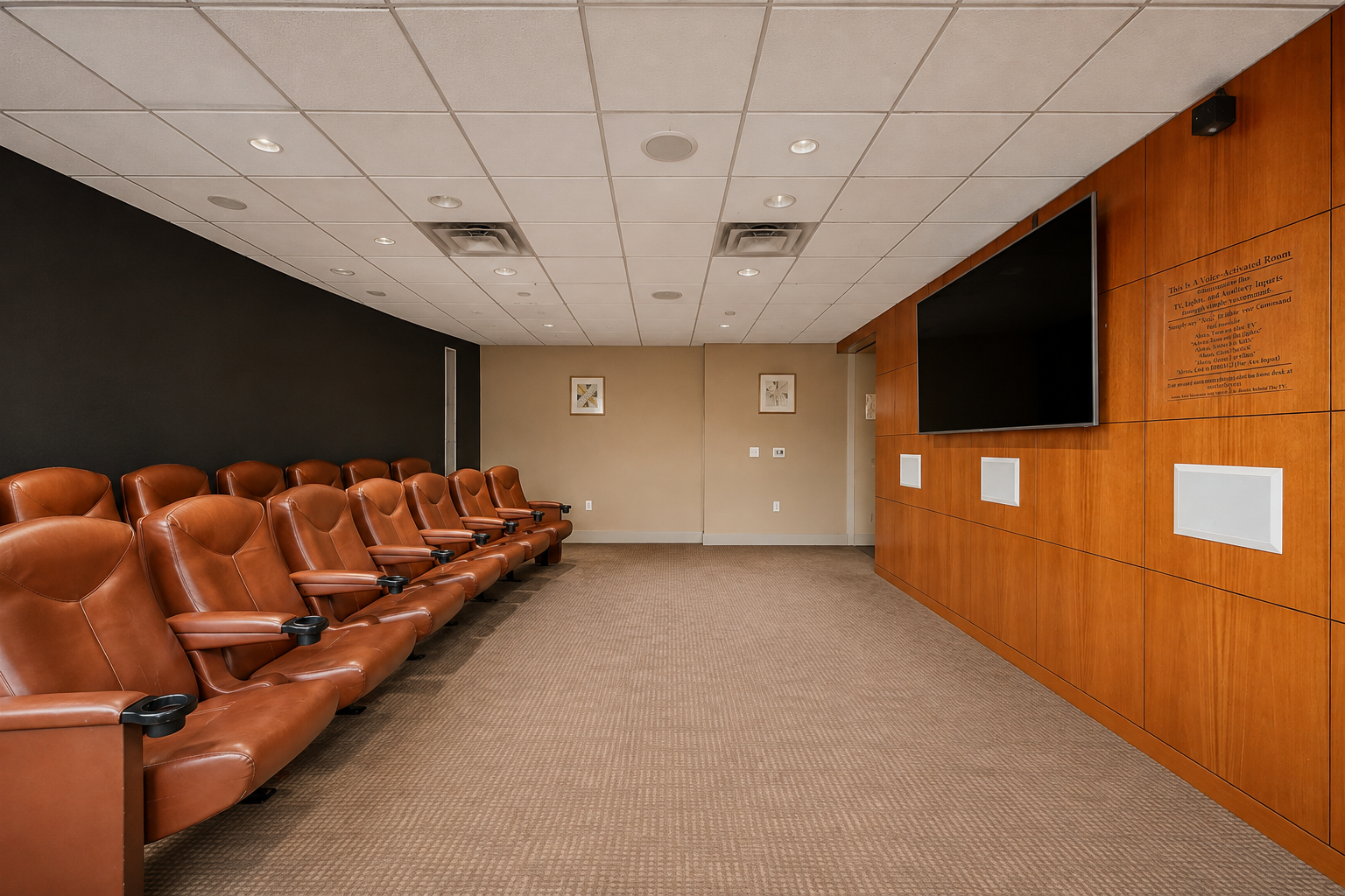 Screening room with brown leather theater seats, a large screen, and warm wood paneling.