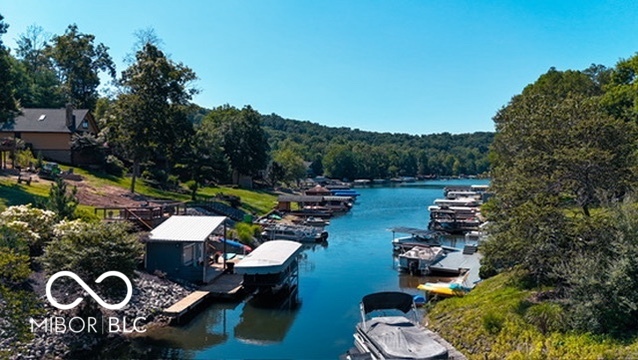 Lake channel lined with private docks and boats between wooded shorelines.