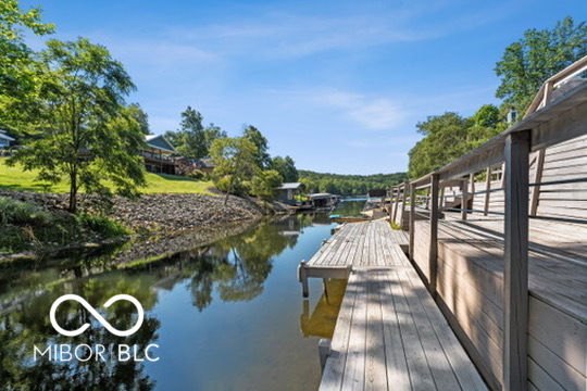Wooden dock and boardwalk beside a calm, tree-lined waterway.