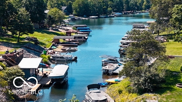 Aerial view of a blue lake with boats at docks along green, tree-lined shores.