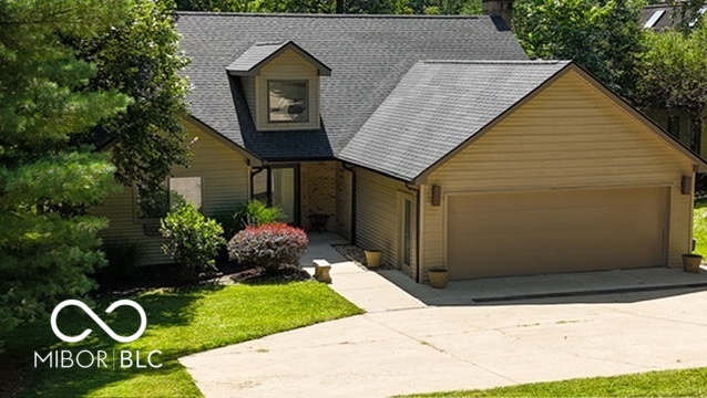Two-story home with an attached double garage, broad driveway, and landscaped front yard.