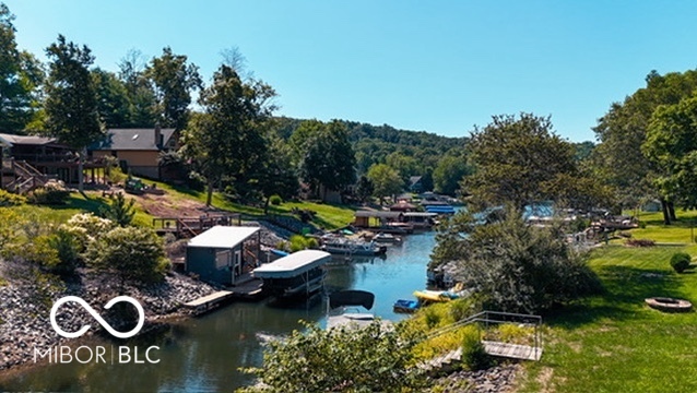 Waterfront homes and docks along a tree-lined lake inlet.