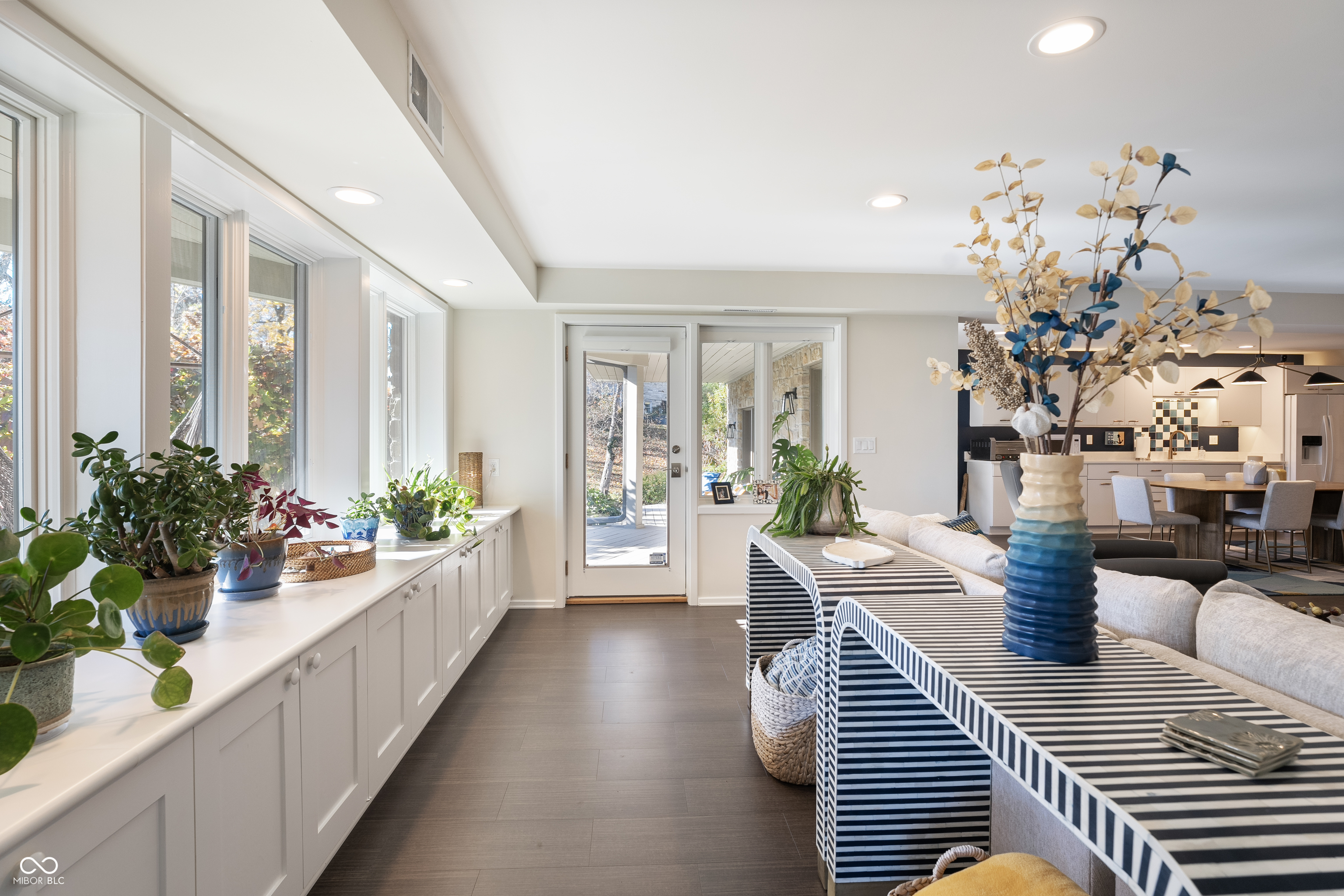 Dining area with striped table, window-side built-in cabinets, and a glass patio door.