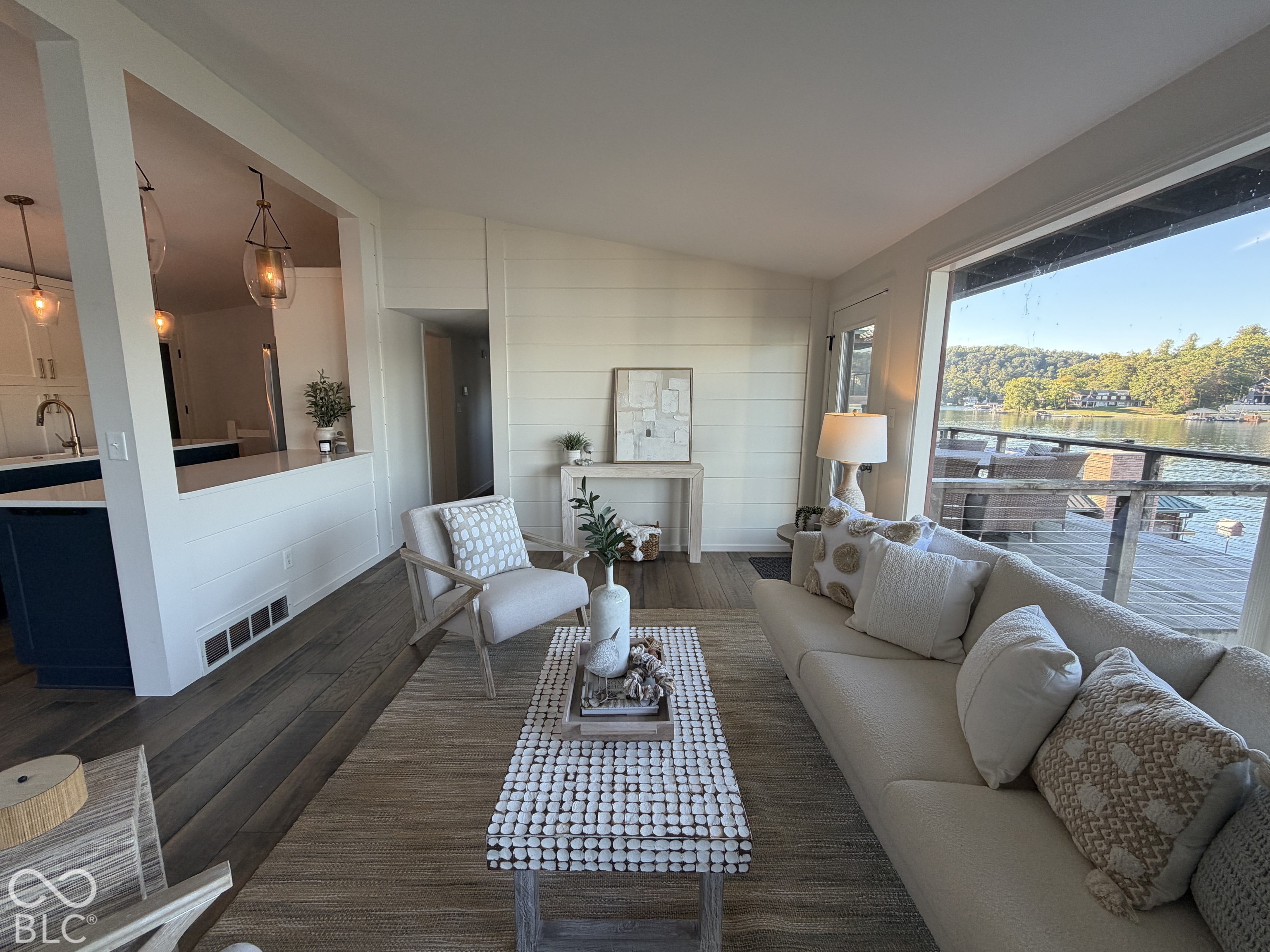 Living room with a white sofa and large window overlooking the lake.