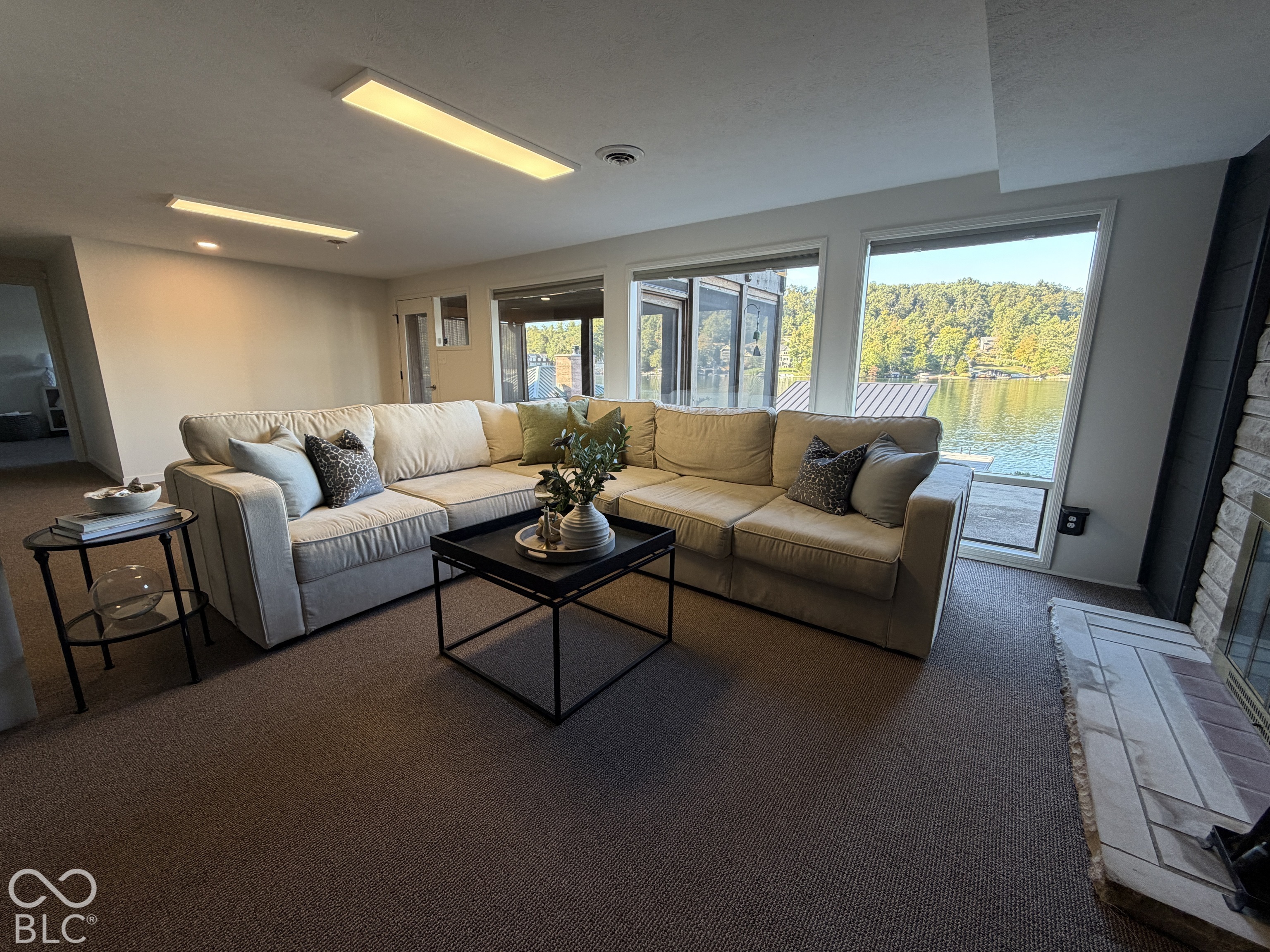 Lakefront living room with a large sectional sofa and wide windows overlooking the water.