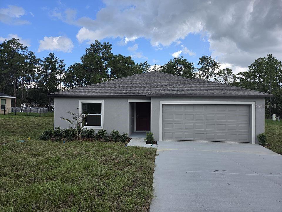 Single-story gray house with a double garage and wide concrete driveway.