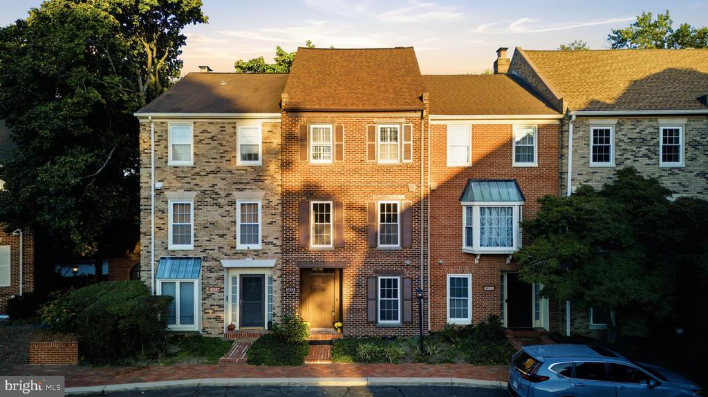 Brick and stone townhome row with a central red-brick facade in golden-hour light.