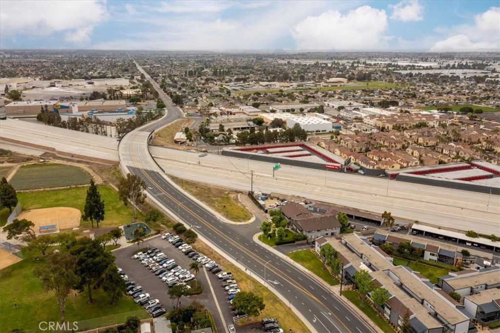 Aerial view of Westminster neighborhoods and commercial buildings beside a freeway interchange.