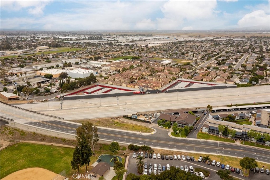 Aerial view of a freeway beside a storage facility and surrounding neighborhoods.