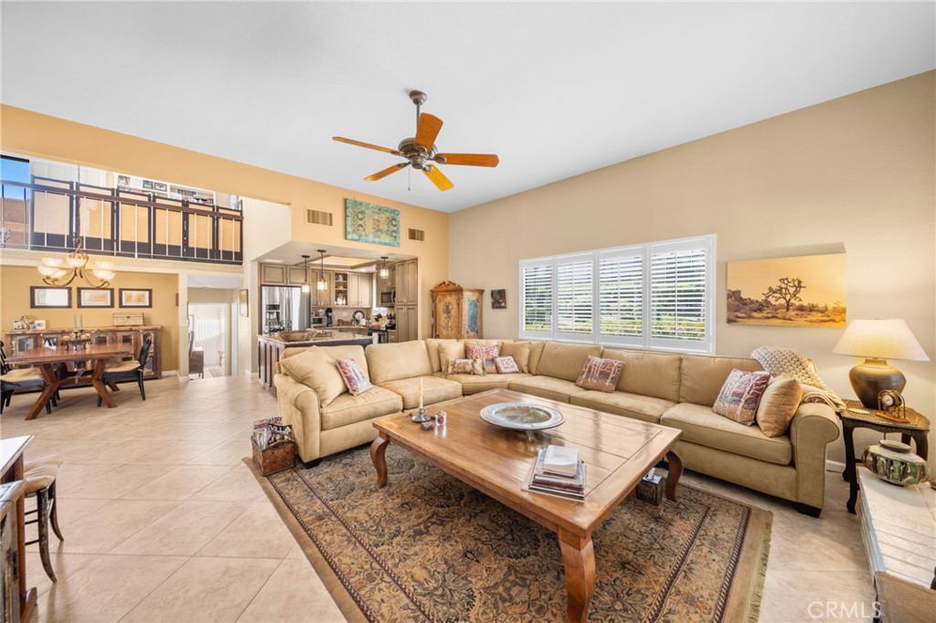 Living room with a beige sectional, wood coffee table, and open kitchen beyond.