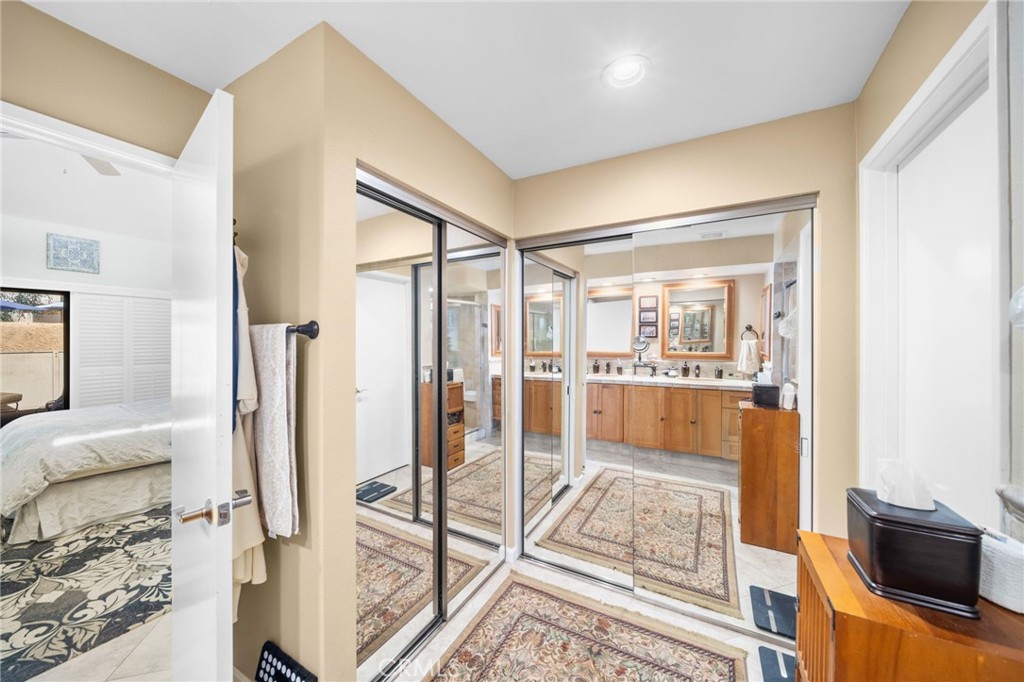 Bathroom vanity and mirrored sliding doors, with a bedroom visible at left.